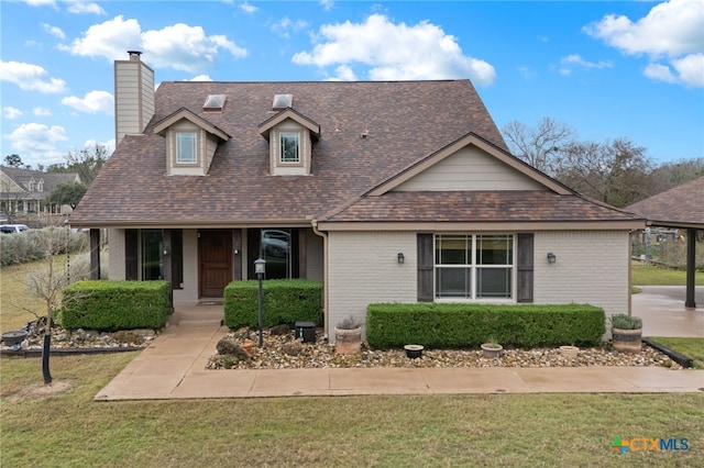 view of front of home featuring brick siding, covered porch, and a front lawn