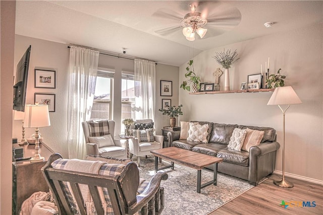 living area with vaulted ceiling, baseboards, a ceiling fan, and wood finished floors