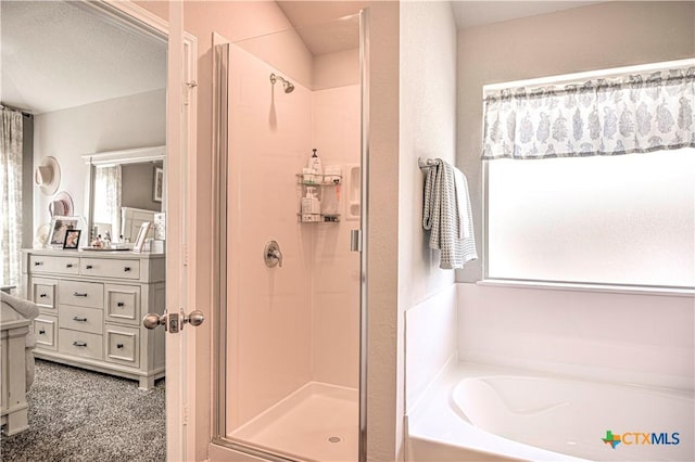 bathroom with a shower stall, vanity, and a garden tub