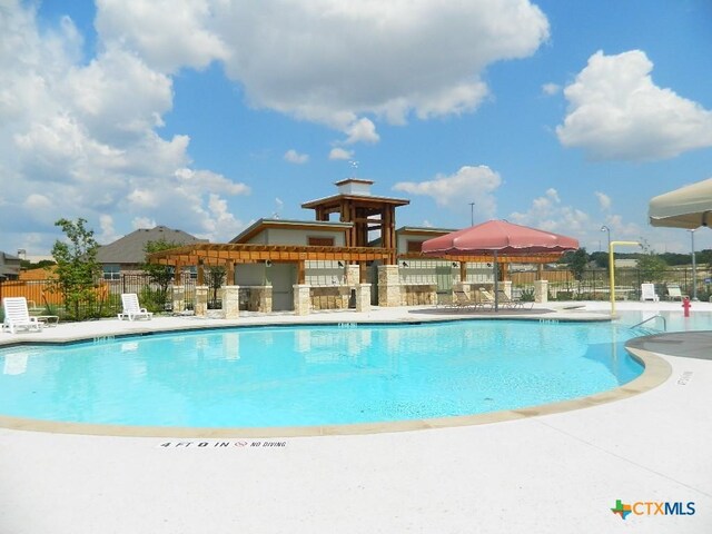 community pool featuring a patio area and fence