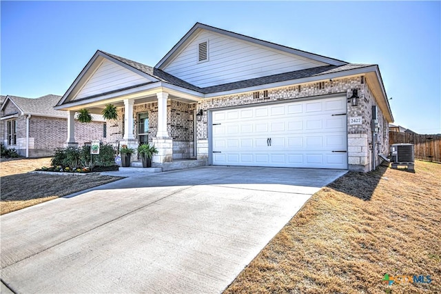 view of front of property with fence, driveway, a porch, an attached garage, and central AC