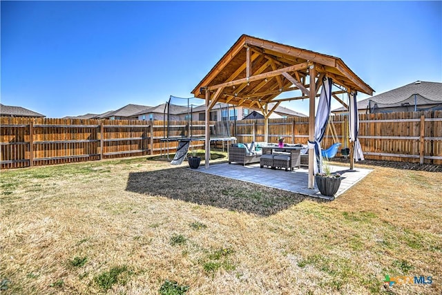 view of yard with a fenced backyard, a patio, and a trampoline