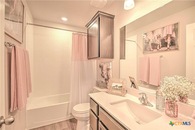 full bathroom featuring toilet, shower / tub combo with curtain, wood finished floors, recessed lighting, and vanity