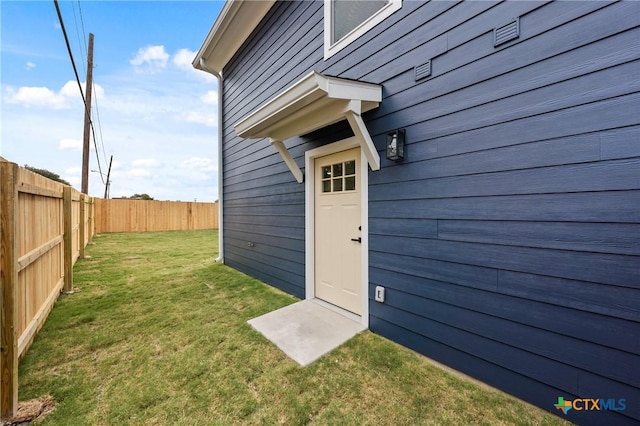 doorway to property with a yard and fence