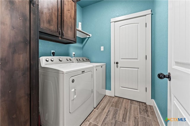 washroom featuring cabinets and washer and clothes dryer