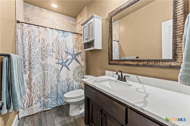 bathroom featuring a shower with curtain, toilet, vanity, and hardwood / wood-style flooring