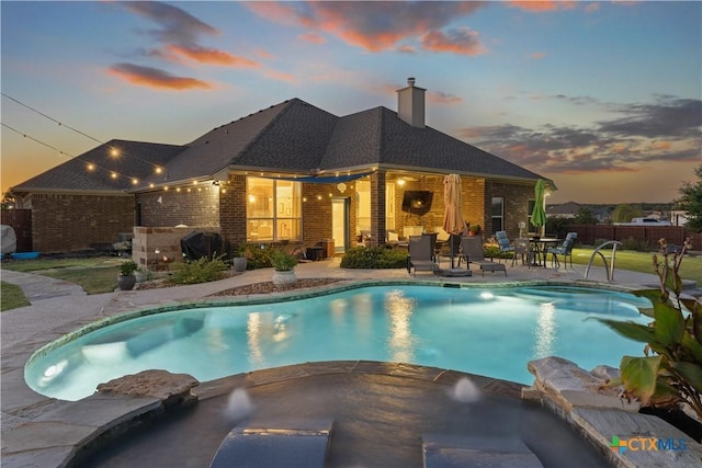 pool at dusk with a patio