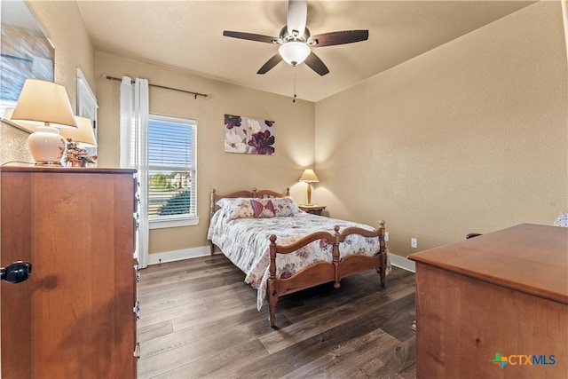 bedroom with dark hardwood / wood-style flooring and ceiling fan