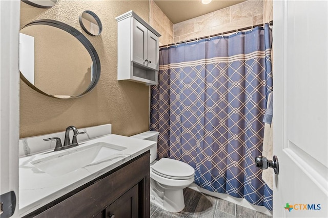 bathroom with vanity, a shower with shower curtain, and toilet