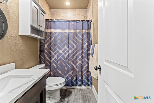 bathroom featuring vanity, a shower with shower curtain, and toilet