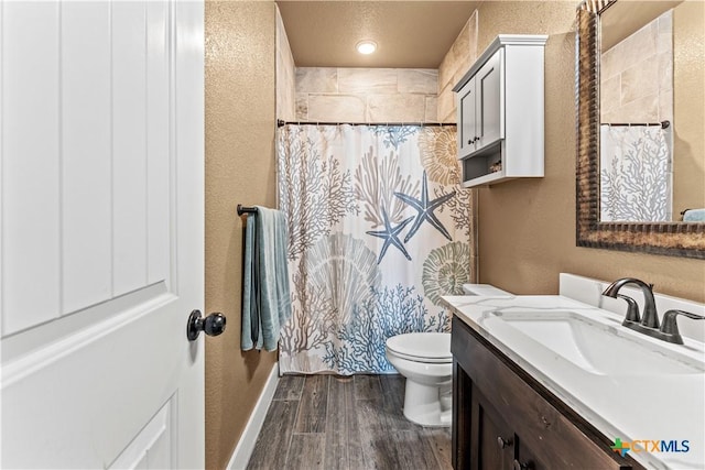 bathroom with walk in shower, vanity, and toilet