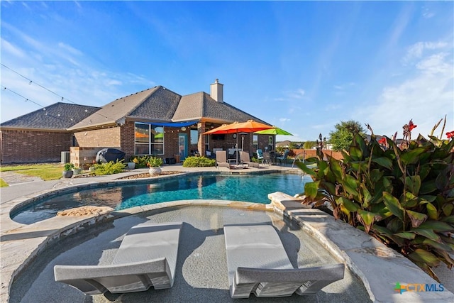 view of pool featuring an in ground hot tub and a patio area