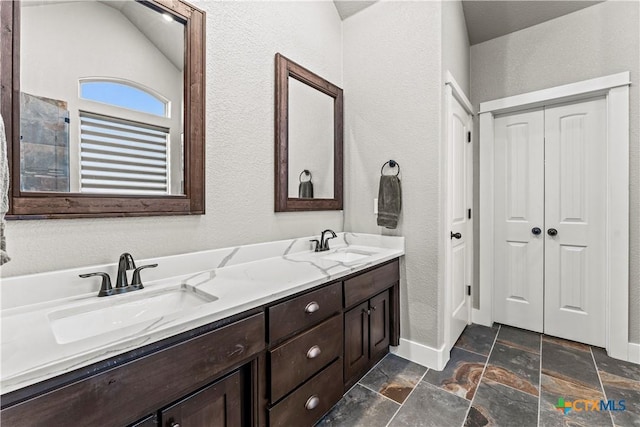 bathroom featuring vanity and lofted ceiling