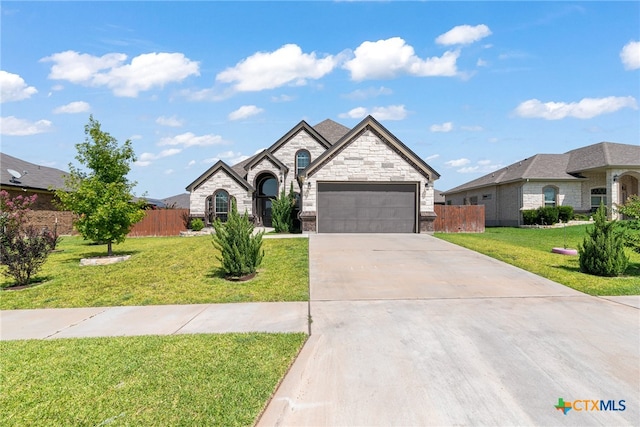 french country home featuring a garage and a front lawn