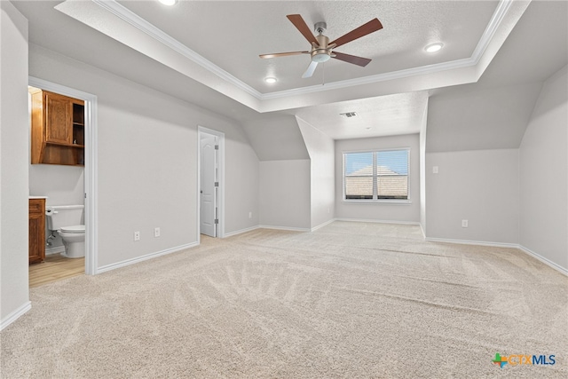 bonus room featuring a textured ceiling, light colored carpet, and ceiling fan