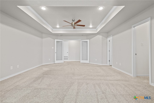 spare room with ceiling fan, light carpet, a raised ceiling, and french doors