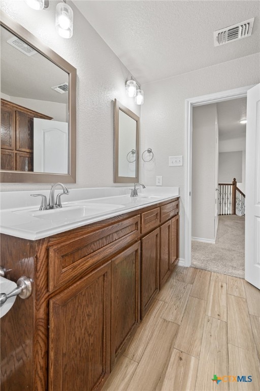 bathroom featuring hardwood / wood-style floors, vanity, and a textured ceiling