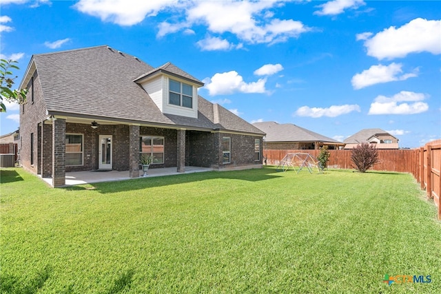 back of house with a patio, a yard, and central air condition unit