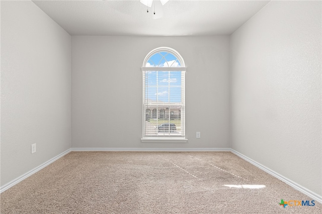 carpeted empty room featuring ceiling fan