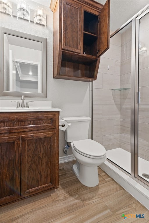 bathroom featuring an enclosed shower, vanity, and toilet