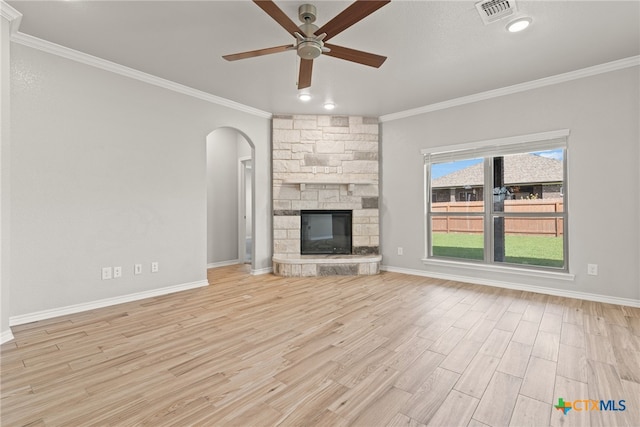 unfurnished living room with ornamental molding, light wood-type flooring, and a stone fireplace