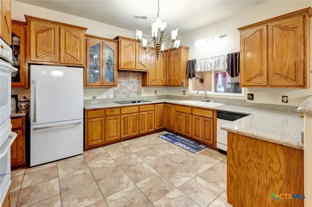 kitchen featuring light stone counters, a chandelier, sink, white appliances, and decorative light fixtures