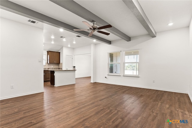 unfurnished living room with beamed ceiling, dark wood finished floors, visible vents, and baseboards