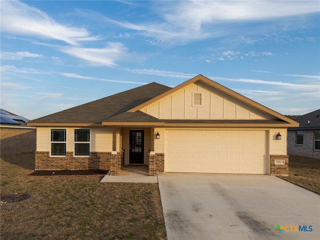 view of front of property featuring driveway, a garage, board and batten siding, and brick siding