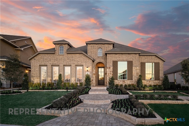 french provincial home featuring a lawn