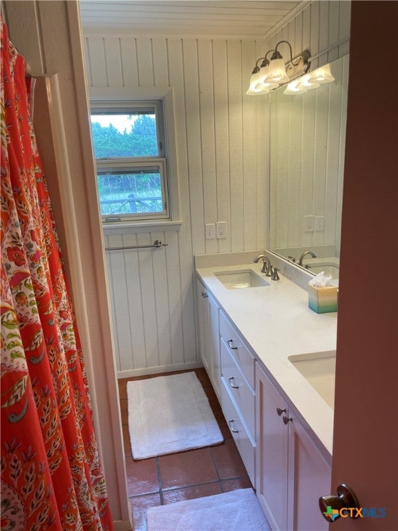 bathroom with wood walls, vanity, and tile patterned floors