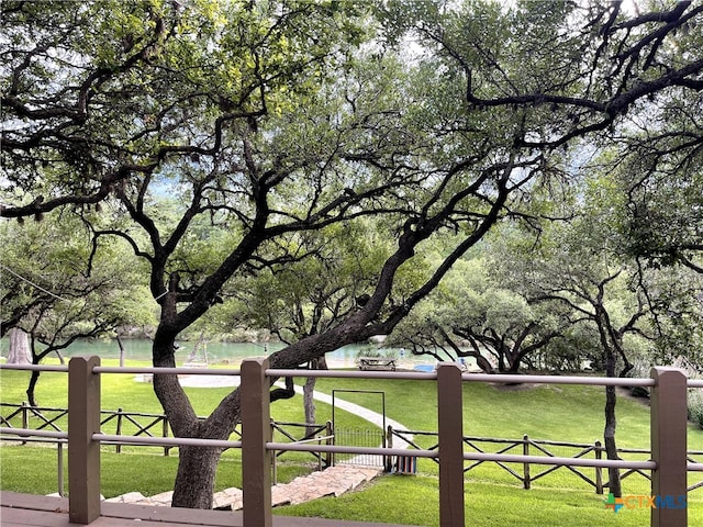 view of property's community with a lawn and a water view