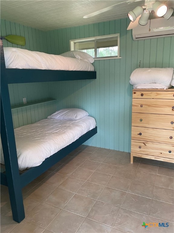 unfurnished bedroom featuring wood walls, tile patterned floors, and a wall mounted air conditioner