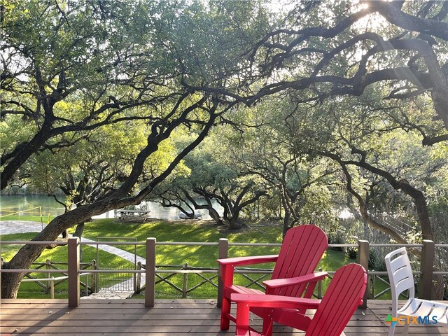 wooden deck with a water view and a yard