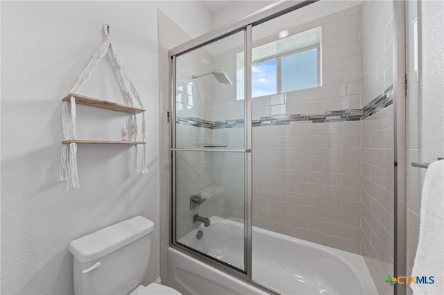 full bathroom with toilet and shower / bath combination with glass door