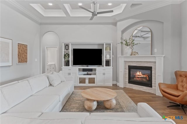 living area featuring ornamental molding, coffered ceiling, a ceiling fan, and wood finished floors