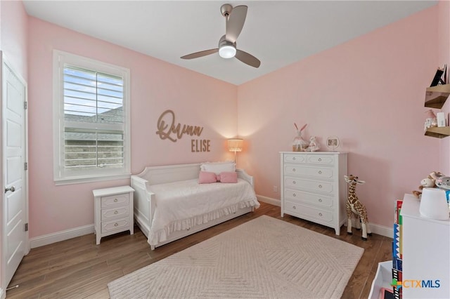bedroom with baseboards, ceiling fan, and wood finished floors
