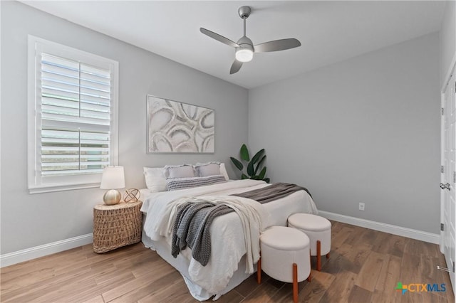 bedroom featuring baseboards, ceiling fan, and wood finished floors