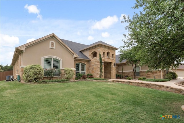 mediterranean / spanish house with stone siding, stucco siding, and a front yard