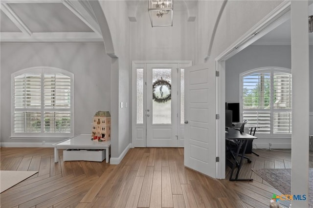 entrance foyer featuring baseboards, ornamental molding, and wood finished floors
