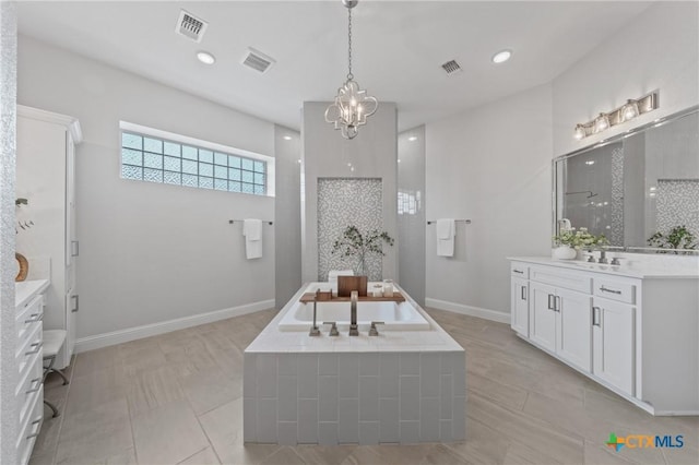 bathroom with a chandelier, visible vents, a garden tub, and vanity