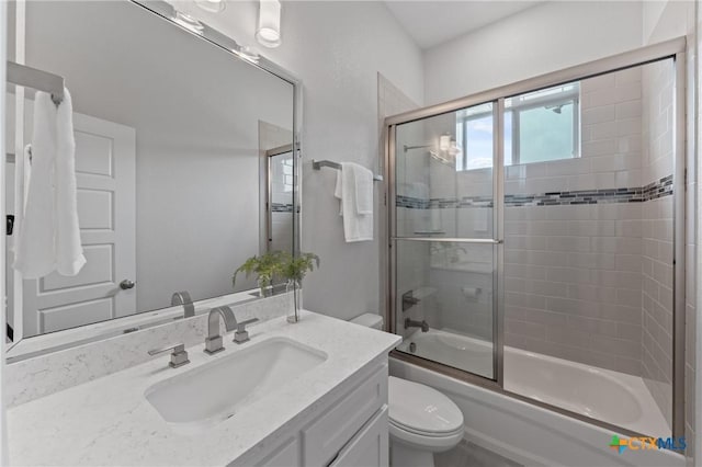 full bathroom with vanity, combined bath / shower with glass door, and toilet
