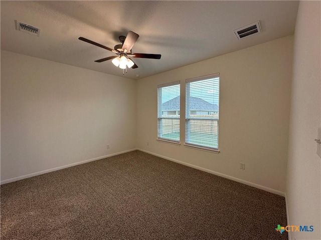 empty room featuring ceiling fan and dark carpet