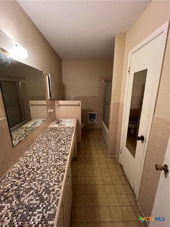 1504 E Central Ave, Temple, TX 76501 - bathroom with vanity, wainscoting, tile walls, tile patterned floors, and heating unit