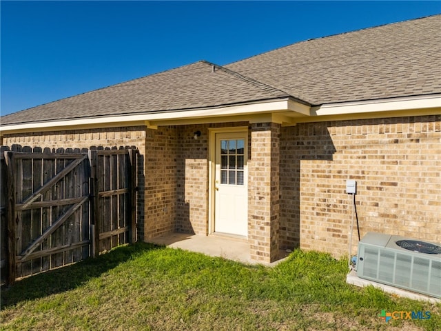 entrance to property with a yard and central AC