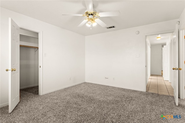 unfurnished bedroom featuring a closet, light colored carpet, and ceiling fan