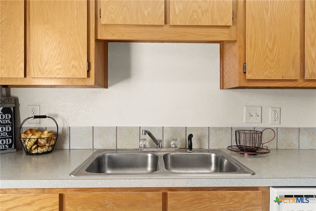 kitchen with backsplash, dishwasher, and sink