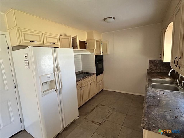 kitchen with dark countertops, tasteful backsplash, under cabinet range hood, black appliances, and a sink