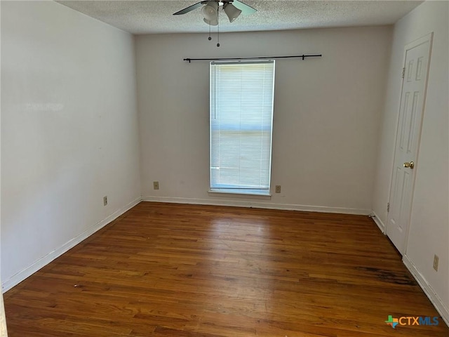 unfurnished room with ceiling fan, baseboards, a textured ceiling, and wood finished floors