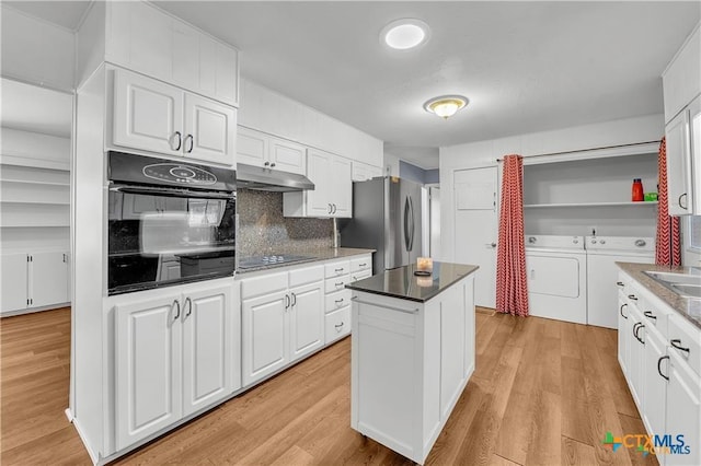404 Oak St, Copperas Cove, TX 76522 - kitchen with black appliances, independent washer and dryer, under cabinet range hood, white cabinetry, and a kitchen island