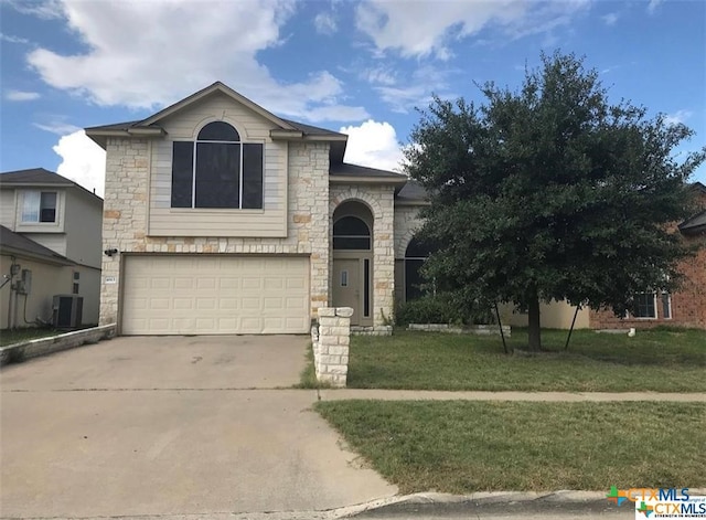 view of front of home featuring a garage, a front lawn, and central AC